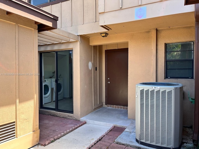 entrance to property featuring cooling unit and washer and dryer