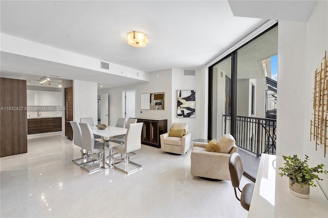 dining space with sink and a wall of windows