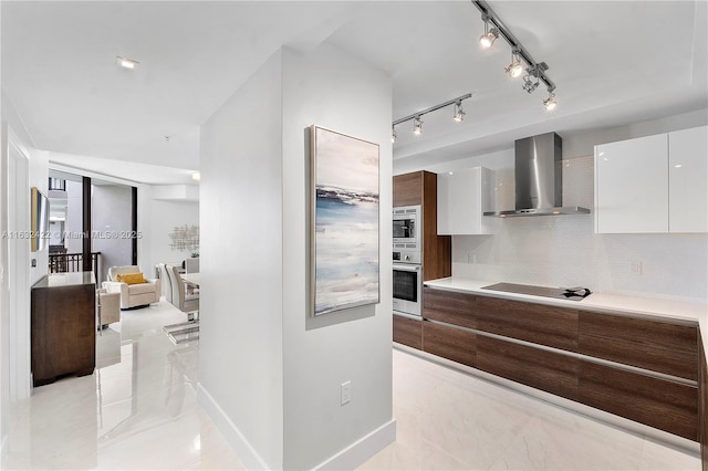 kitchen with backsplash, white cabinets, wall chimney exhaust hood, and stainless steel appliances