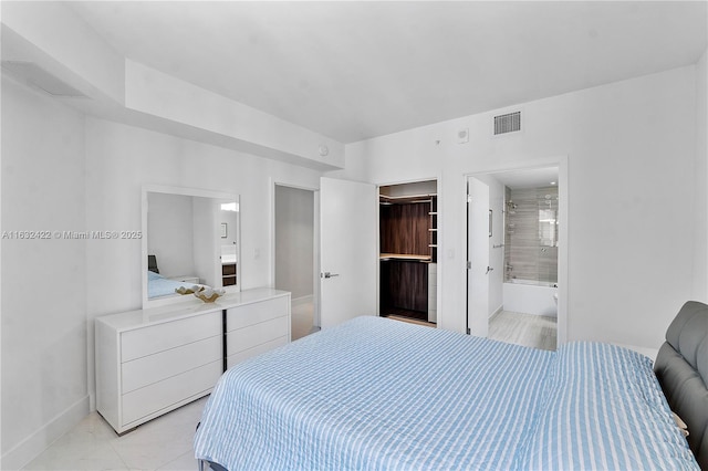 bedroom featuring light tile patterned floors and connected bathroom