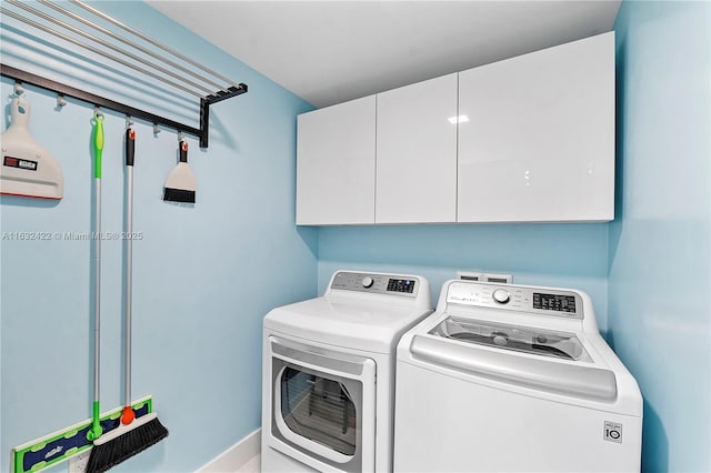 washroom with cabinets and washer and clothes dryer