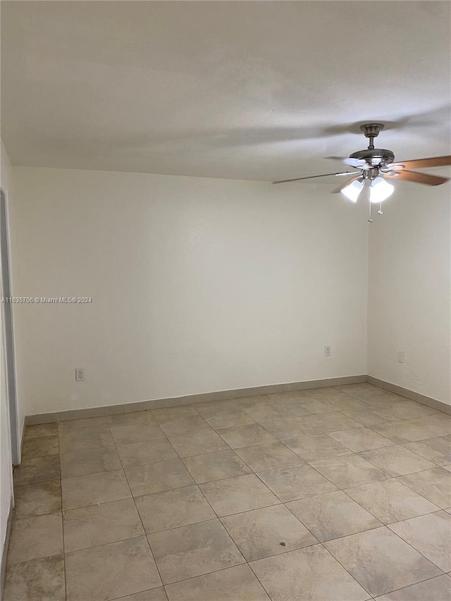 empty room with ceiling fan and light tile patterned floors