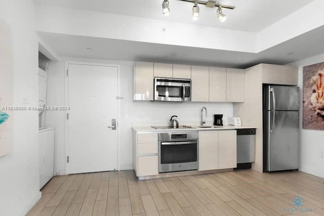 kitchen with sink, appliances with stainless steel finishes, and light wood-type flooring