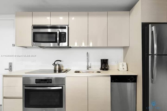 kitchen featuring sink, cream cabinets, and stainless steel appliances