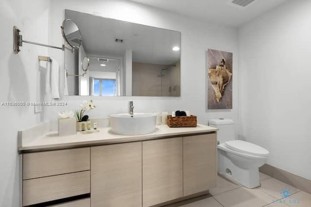 bathroom featuring vanity, tile patterned floors, and toilet