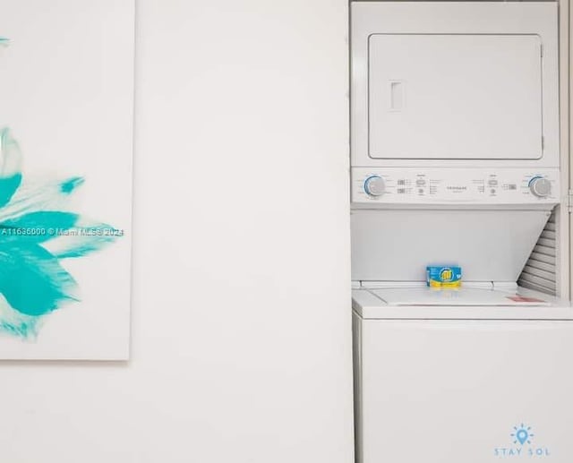 clothes washing area with stacked washer / dryer