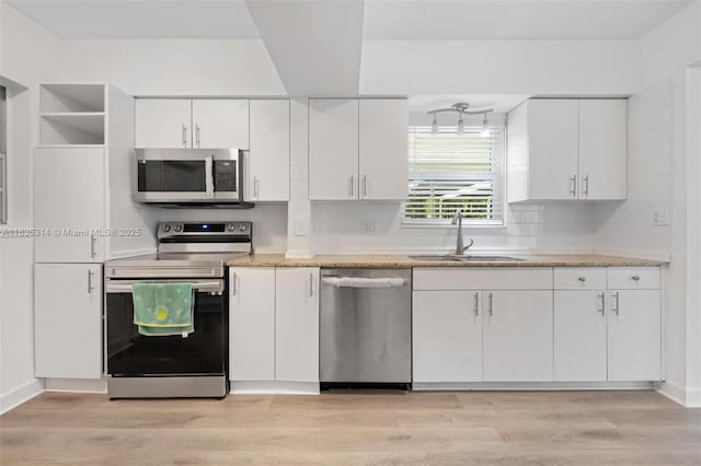 kitchen with stainless steel appliances, white cabinetry, and sink