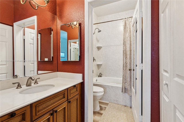 full bathroom featuring tiled shower / bath, a textured wall, toilet, and vanity