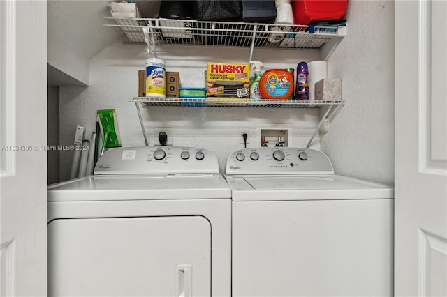 laundry room featuring washing machine and dryer, laundry area, and a textured wall