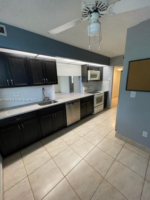 kitchen with sink, light tile patterned floors, white appliances, tasteful backsplash, and ceiling fan