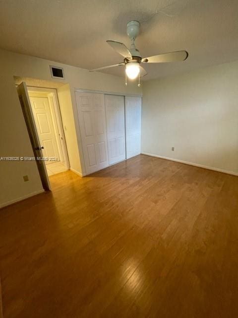 unfurnished bedroom featuring light hardwood / wood-style floors, ceiling fan, and a closet