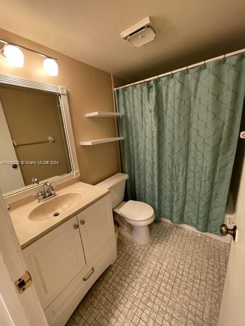 bathroom featuring toilet, tile patterned flooring, and vanity