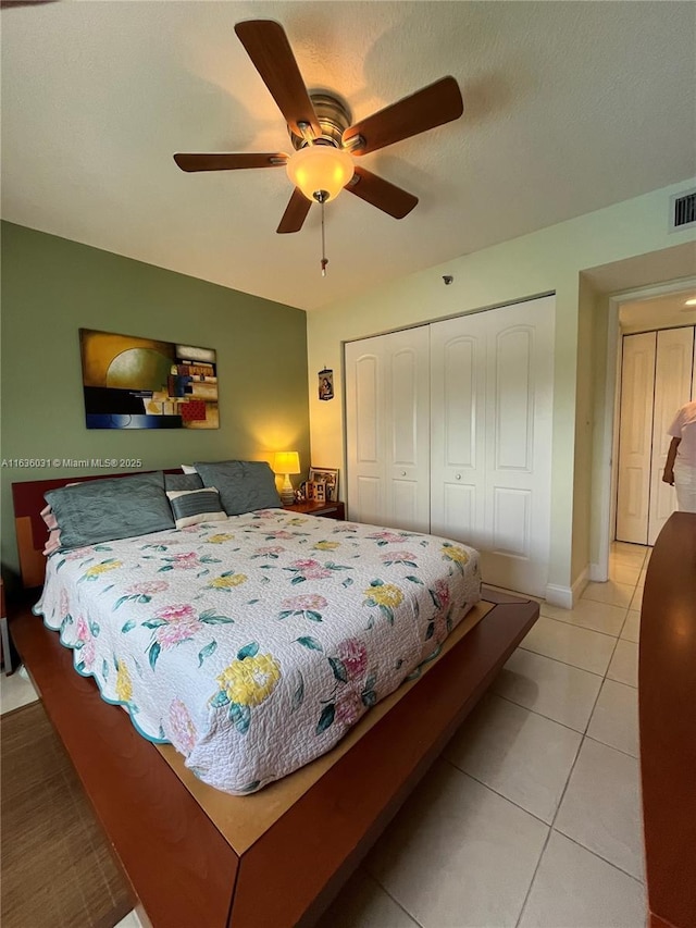 bedroom featuring ceiling fan, a closet, and light tile patterned floors