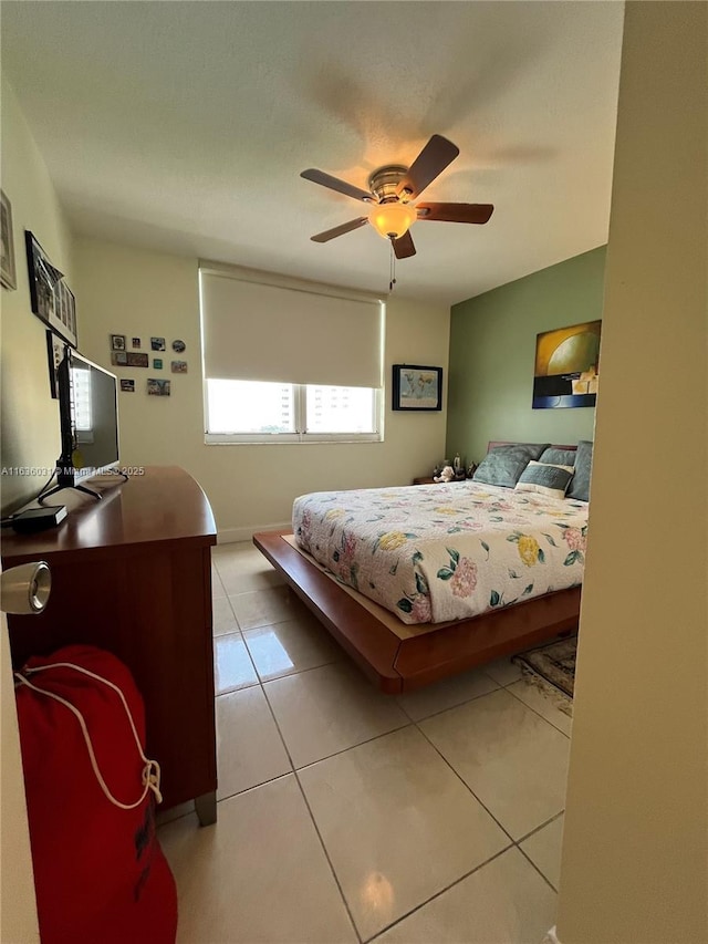 tiled bedroom featuring ceiling fan