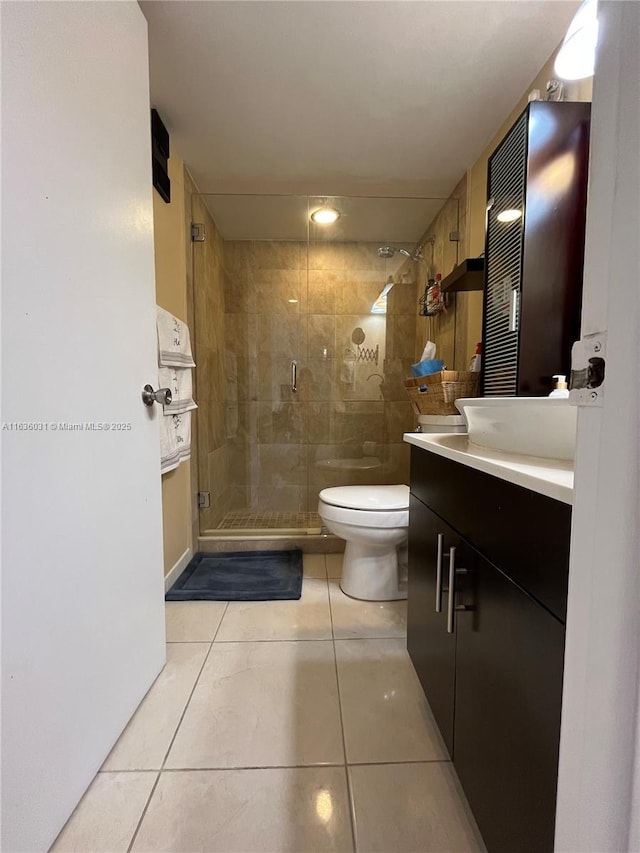 bathroom with tile patterned flooring, vanity, a shower with door, and toilet