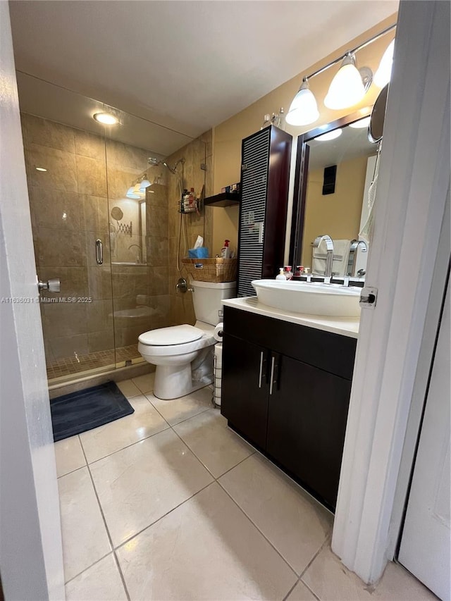 bathroom featuring tile patterned flooring, vanity, an enclosed shower, and toilet