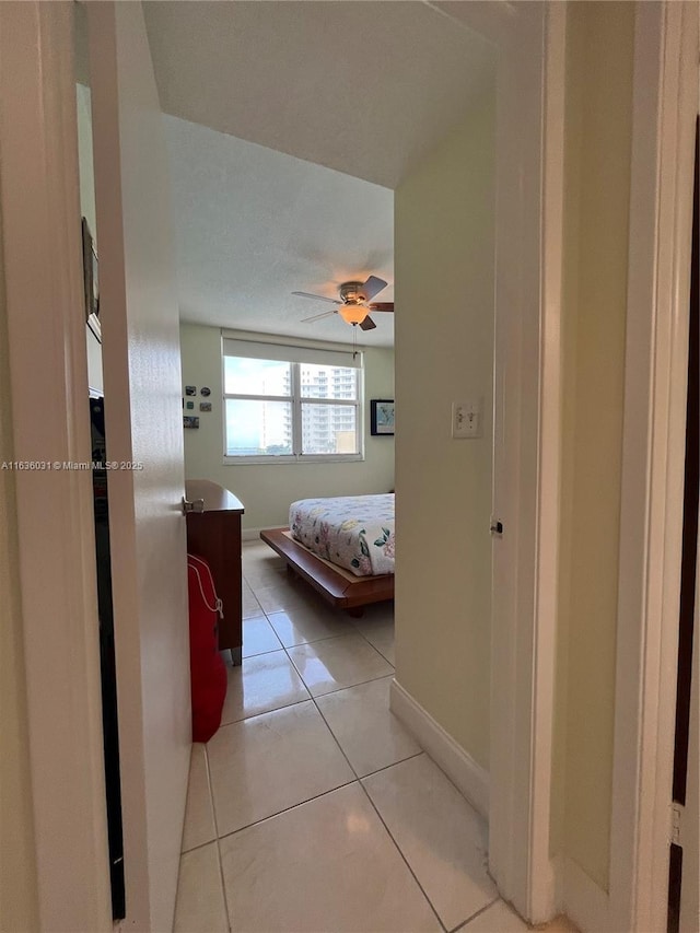 unfurnished bedroom featuring light tile patterned floors and ceiling fan