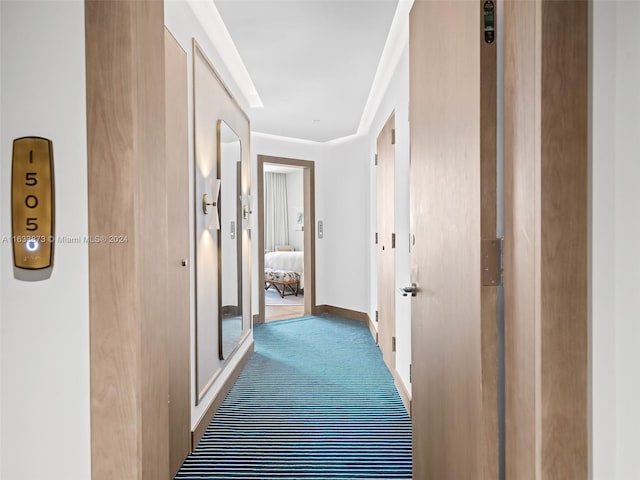 hallway featuring crown molding and carpet