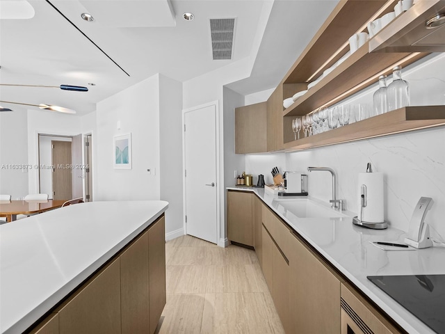 kitchen with tasteful backsplash, black electric cooktop, and sink