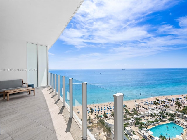 balcony featuring a water view and a beach view