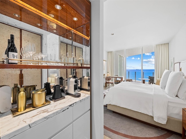 bedroom featuring a water view and indoor bar