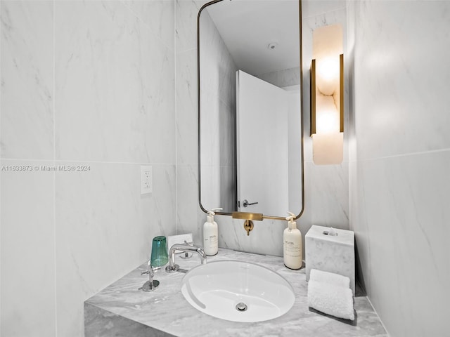 bathroom featuring vanity and tile walls