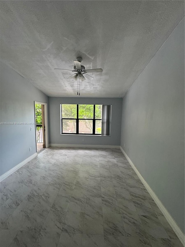 tiled spare room featuring a textured ceiling and ceiling fan