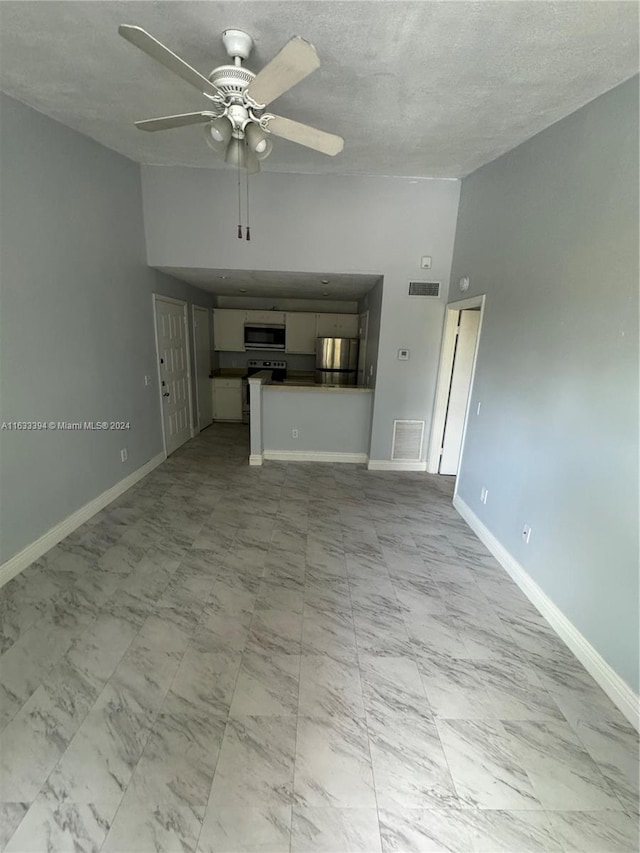 unfurnished living room featuring a high ceiling, light tile patterned floors, and ceiling fan