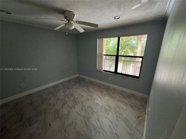 empty room featuring a textured ceiling, tile patterned floors, and ceiling fan