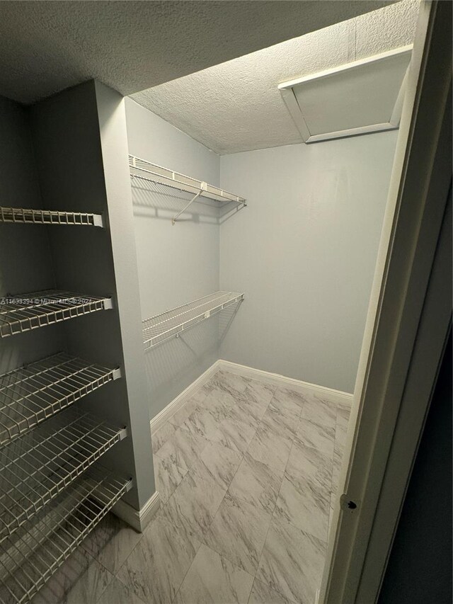 walk in closet with tile patterned floors