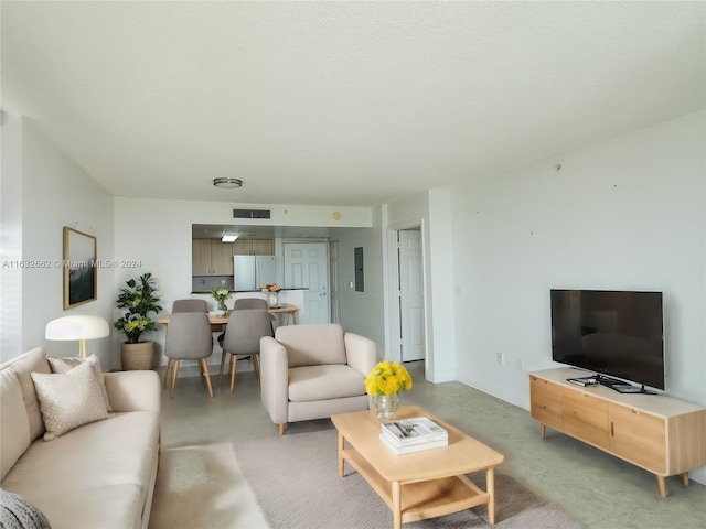 living room featuring electric panel and concrete flooring