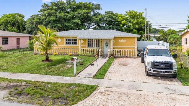 single story home featuring a porch and a front lawn