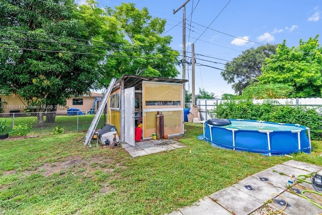 view of yard featuring an outbuilding and a fenced in pool