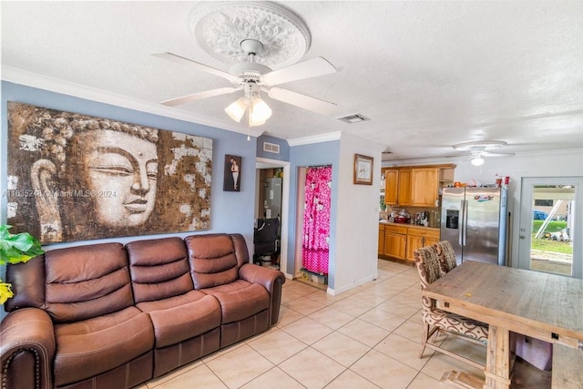 tiled living room with a textured ceiling, ceiling fan, and ornamental molding