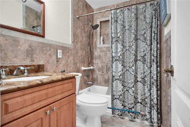 full bathroom with tile patterned flooring, toilet, vanity, shower / tub combo with curtain, and tile walls