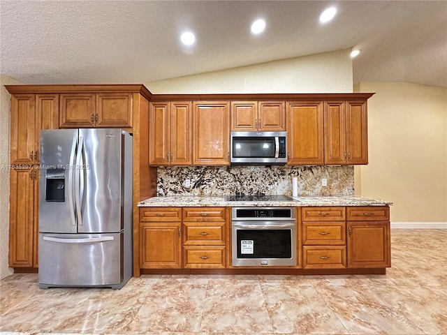 kitchen featuring backsplash, light stone countertops, stainless steel appliances, and vaulted ceiling