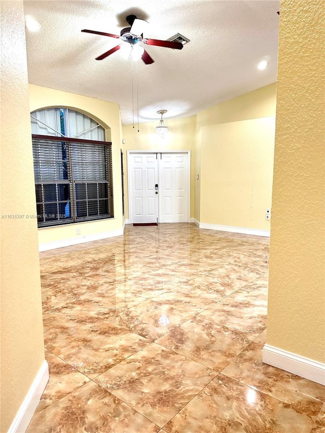 interior space featuring ceiling fan and a textured ceiling