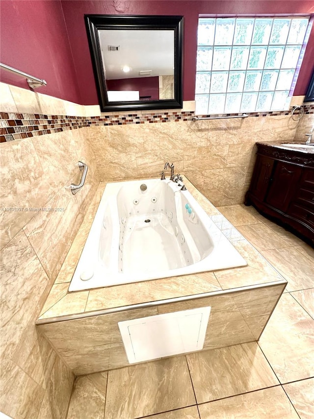 bathroom featuring vanity and tiled tub