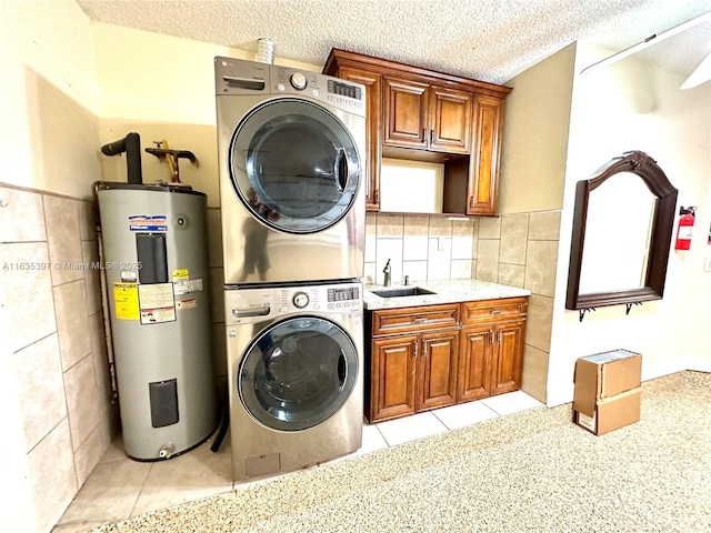 washroom with sink, cabinets, electric water heater, stacked washer and dryer, and light tile patterned floors