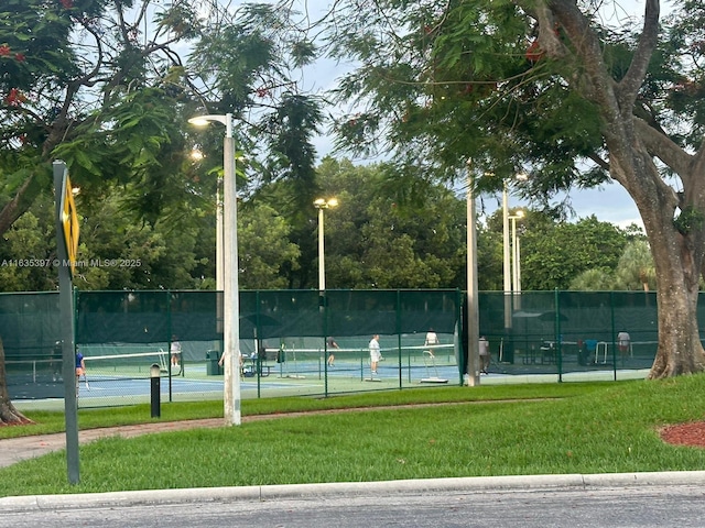 view of tennis court featuring a yard