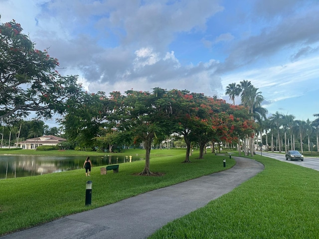 surrounding community featuring a lawn and a water view