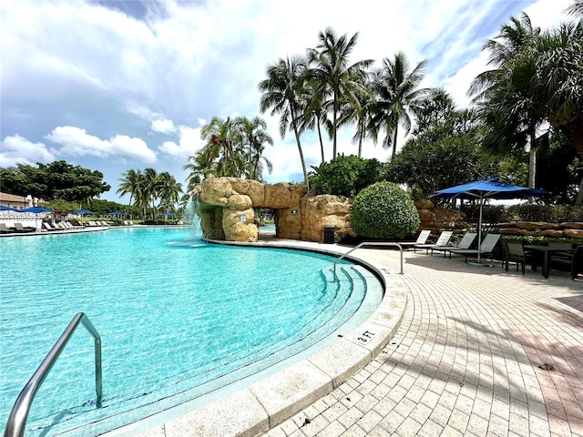 view of pool featuring pool water feature and a patio