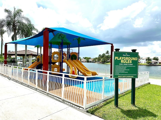 view of jungle gym with a swimming pool and a water view