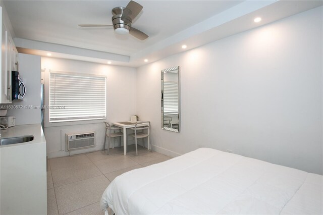 bedroom with a wall mounted air conditioner, sink, ceiling fan, and light tile patterned floors