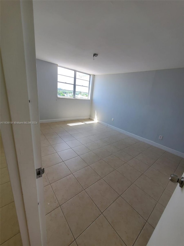 unfurnished room featuring light tile patterned floors