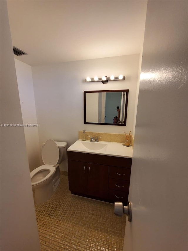 bathroom with vanity, tile patterned flooring, and toilet