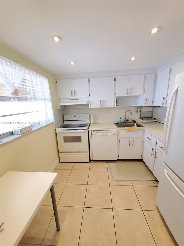 kitchen with sink, light tile patterned flooring, white cabinets, and white appliances