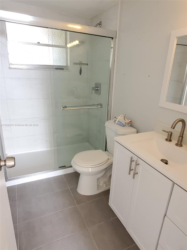 7900 Tatum Waterway Dr Unit 502, Miami Beach, FL 33141 - full bathroom featuring a shower with shower door, tile patterned flooring, vanity, and toilet