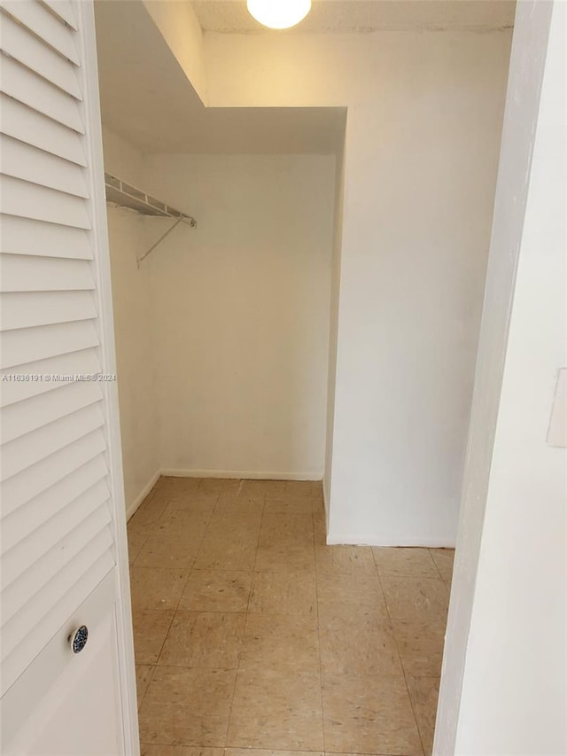 walk in closet with light tile patterned floors