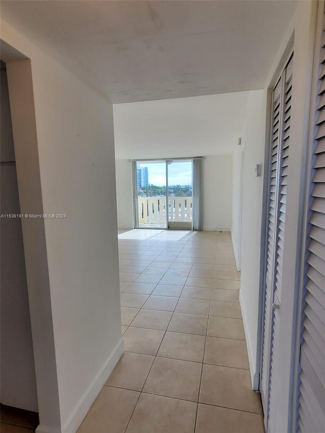 7900 Tatum Waterway Dr Unit 502, Miami Beach, FL 33141 - corridor featuring floor to ceiling windows, light tile patterned floors, and baseboards
